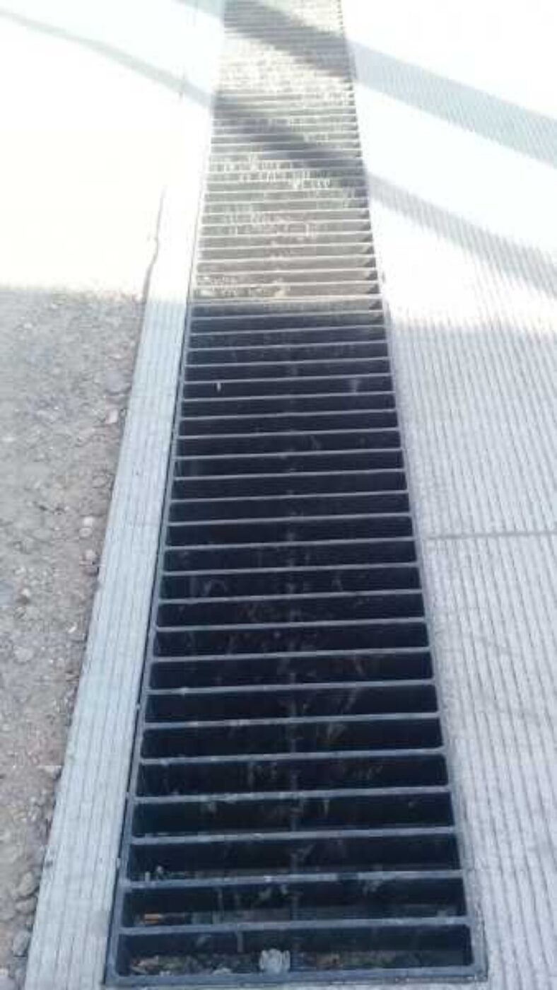 Canaleta de drenaje industrial protegida con rejilla metálica